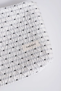 Dettaglio ravvicinato della borsa in tessuto a pois con texture a pieghe e logo H&R