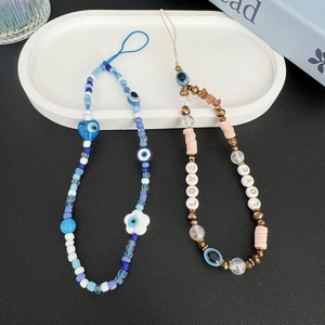 Detail of beaded evil eye phone charms with colorful polymer clay and LOVE lettering
