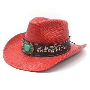 Détail d'un chapeau de cowboy en paille rouge avec pierre turquoise et broderie fleurie