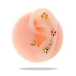 Detailed display of colorful gemstone ear studs on ear model for cartilage piercing jewelry