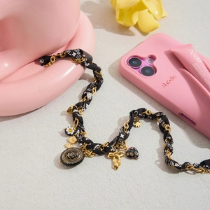 Collier vintage en métal doré avec breloques fleurs noires et ruban de tissu tressé