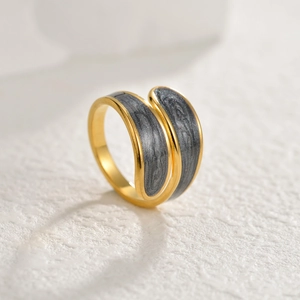 Minimalistischer Goldring mit dunkelgrauer Marmor-Einlage auf weißer Oberfläche