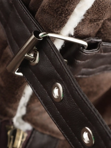 Detailed macro shot of brown leather vest featuring warm sherpa lining and metal hardware