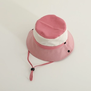 Close-up of pink and cream bucket hat featuring adjustable windproof cord and snap buttons