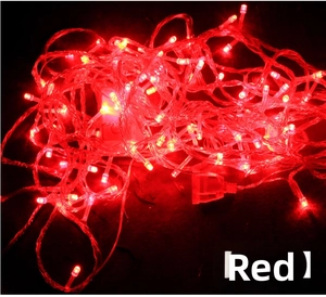 Detail of red LED fairy lights with transparent wire and white controller on black background