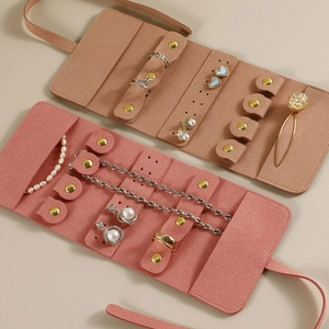 Detail of suede jewelry travel roll with earring panel and necklace holders