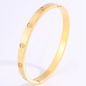 Detailed view of gold plated stainless steel bangle with sunburst pattern engraving