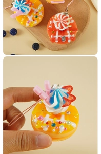Primer plano de un llavero de dónat de 4,5 cm con decoraciones de crema y perlas