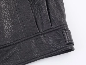 Dettaglio del bomber in ecopelle nera con texture martellata e doppie cuciture di qualità