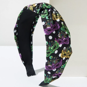 Detail of fabric headband with carnival mask prints and top knot design