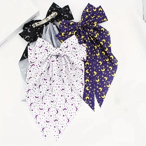 Three bow hair clips with moon and star prints in black, white, and purple fabric colors