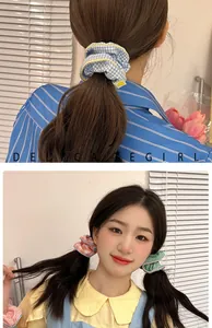 Close-up of pastel checkered fabric scrunchies with yellow piping on a model