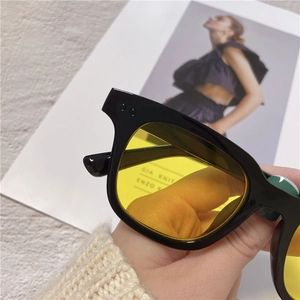 Detail shot of stylish yellow tinted lenses and black frame of trendy sunglasses