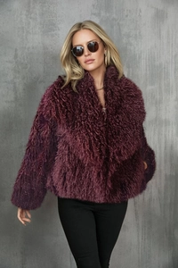 Detailed texture of dark purple fluffy faux fox fur coat with a wide lapel collar