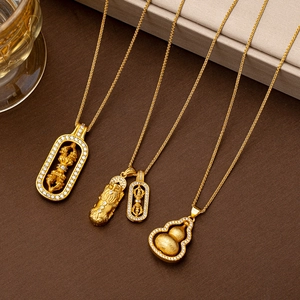Detailansicht goldener Halsketten mit Vajra-, Pixiu- und Kürbis-Anhängern und weißen Zirkonia