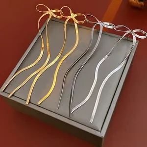 Boucles d'oreilles nœuds plaquées or et argent avec de longs glands en chaîne
