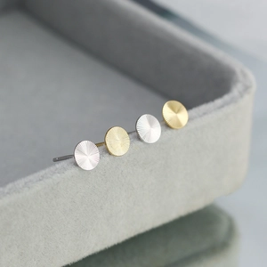 Macro view of S925 sterling silver round stud earrings with radial brushed texture