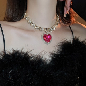 Close-up of a pink heart-shaped crystal necklace with rhinestone chain on a model