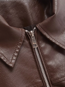 Detail of dark brown faux leather pilot jacket showing collar texture and zipper quality