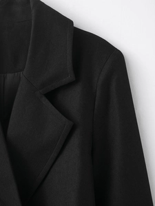 Close-up of black blend coat showing premium twill fabric texture and collar stitching