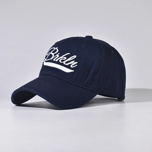 Close-up of white Brkln embroidery and premium cotton twill texture on a navy baseball cap