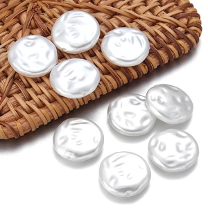 Close-up of irregular flat round white ABS imitation pearls with holes on woven mat