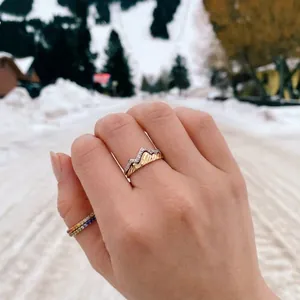 Mountain peaks ring set with micro-pave diamonds on a natural snow background