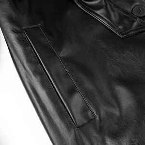 Detailed macro shot of premium black leather coat showing fine texture and side pocket