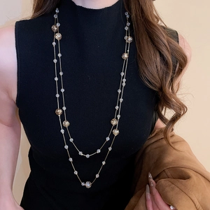 Detail of elegant double-layer necklace with amber and clear crystal beads on a model