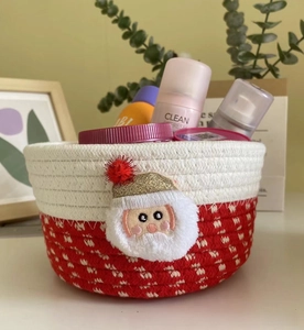 Detail of red and white woven cotton rope storage basket with plush Santa decoration