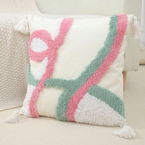 Close-up of tufted geometric patterns and decorative tassels on the cream pillow cover