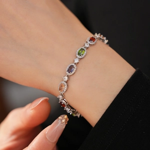 Macro detail of silver tennis bracelet featuring multicolor oval zircons and micro-pave setting