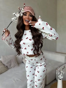 Close-up of cherry print ribbed pajamas featuring red wavy lettuce trim detailing
