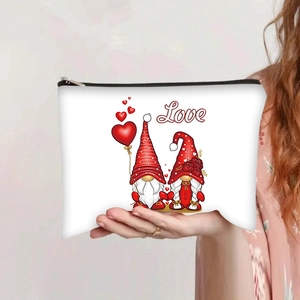 Close-up of white canvas makeup bag featuring Love text and cartoon gnome prints
