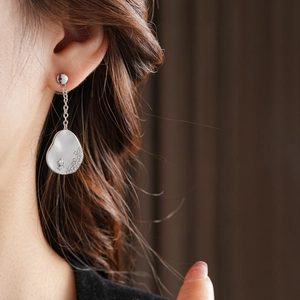 Gros plan sur boucle d'oreille asymétrique en argent avec cristaux sur modèle