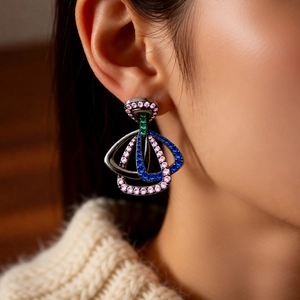 Détail de boucles d'oreilles vintage géométriques avec zircons colorés portées par un mannequin