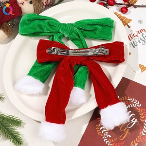 Macro shot of red and green velvet Christmas bow hair clips with white plush pom-poms