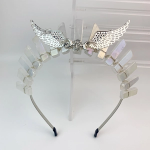Silver wedding crown with crystal prisms and winged star centerpiece on display