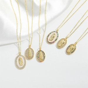 Macro shot of gold-plated Guanyin pendant necklaces with zircons on white silk background