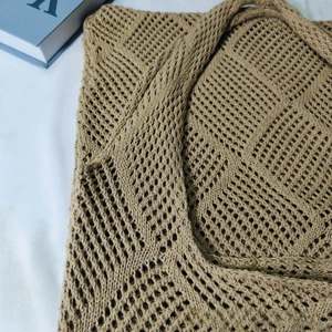 Detailed close-up of hollow knit tote bag with large diamond mesh pattern in camel beige