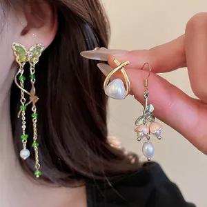 Elegant floral and pearl earrings set with gold finish and butterfly tassels on model
