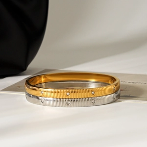 Detail showing vertical striped stainless steel bangles with sparkling crystals