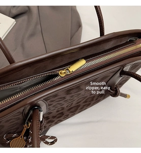 Détail de la fermeture éclair dorée lisse et du motif léopard sur un grand sac
