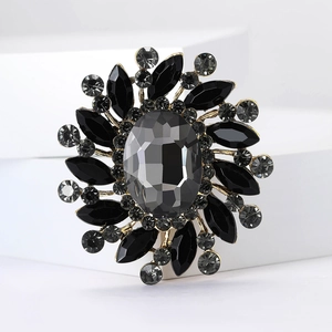 Macro shot of sunburst flower brooch with grey oval stone and black marquise petals