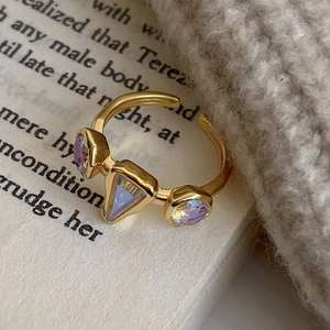 Adjustable S925 sterling silver ring with purple zircon stones on a vintage book page