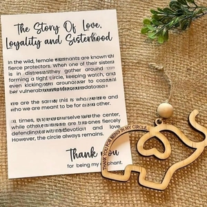 Detailed view of wood elephant pendant with heartfelt text on rustic burlap background