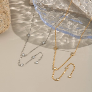 Elegant gold and silver link necklaces with cubic zirconia on textured rock background