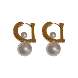 Eleganti orecchini a perla placcati oro con lettera D e design a doppia perla su bianco