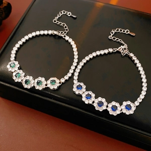 Détail de bracelets tennis floraux en argent avec cristaux de zircon vert et bleu