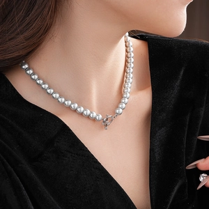 Detailed view of gray pearl necklace featuring a silver OT buckle worn on a model
